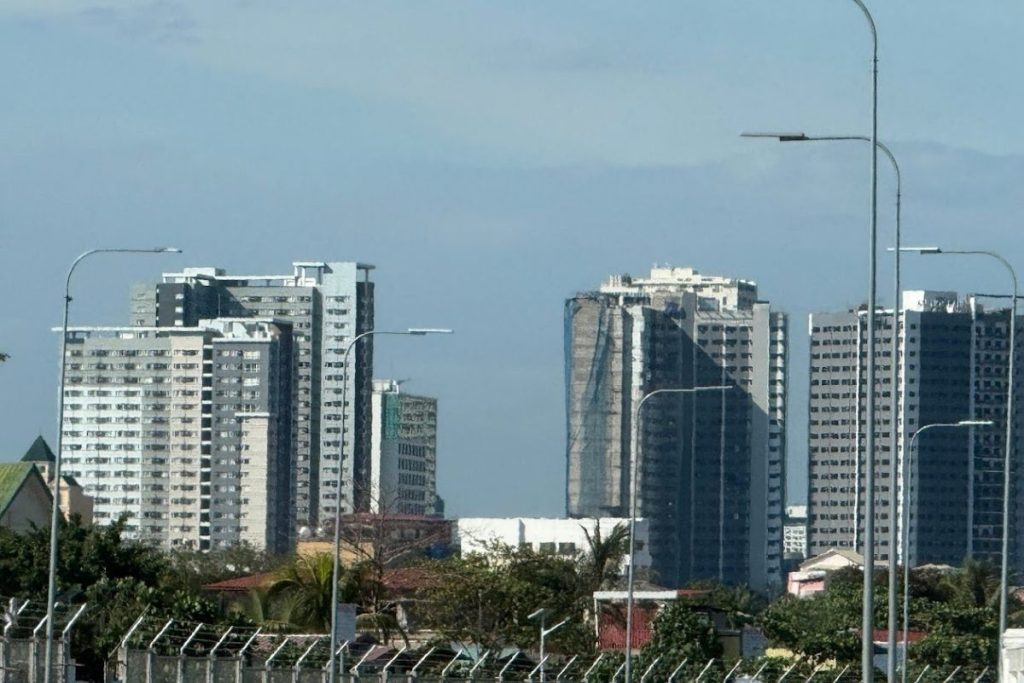 Modern high-rise apartment buildings rising above a developing city landscape, representing the idea of building a joyful home in a growing and expanding city.