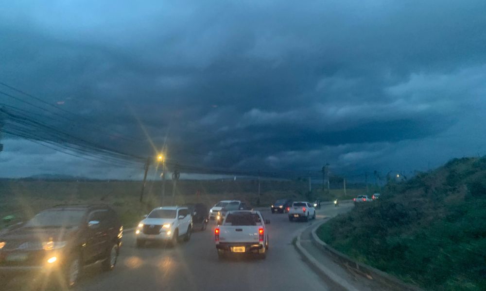 Cars driving along a highway under dark, stormy skies with heavy clouds overhead, representing the idea of creating stability even when everything around you feels uncertain or expanding.