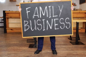 A person holding a family business sign indicating need for a website.